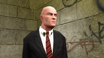 Bald Man In Suit And Tie In Front Of Brick Wall GIF