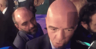 Bald Man In Suit And Tie Interviewed GIF