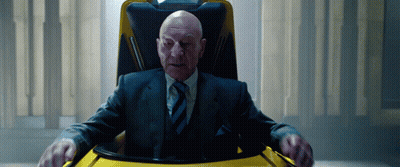 Bald Man In Suit And Tie Sitting In Chair GIF