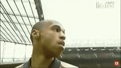 Bald Man In Suit And Tie Sitting In Front Of Soccer Player GIF
