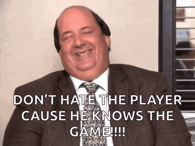 Bald Man in Suit Saying Don't Hate the Player Cause He Knows the Game