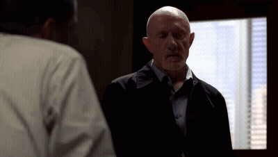 Bald Man In Suit Talking To Another Man GIF
