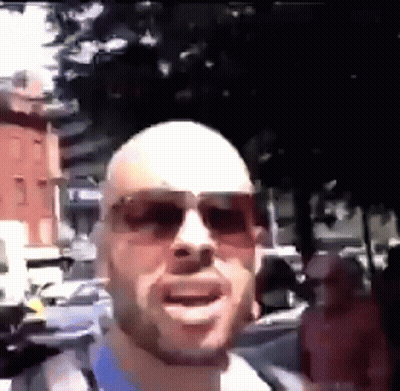 Bald Man In Sunglasses On Crowded Street GIF
