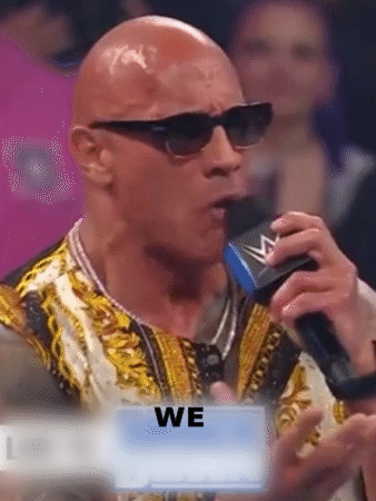 Bald Man In Sunglasses Speaking Into Microphone Holding Sign We GIF