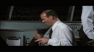 Bald Man In White Shirt And Black Tie Sitting At Machine GIF