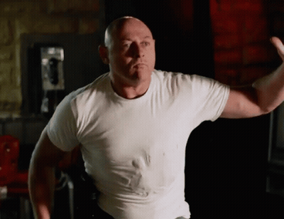 Bald Man In White T-Shirt Flexing Muscles GIF