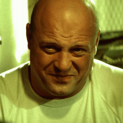 Bald Man In White T-Shirt Looking At Camera GIF
