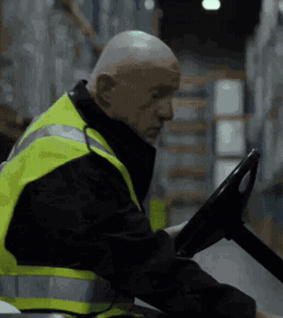 Bald Man In Yellow Safety Vest Driving Forklift GIF