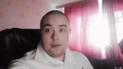 Bald Man Looking At Camera By Window GIF