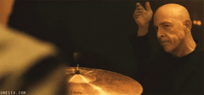 Bald Man Playing Drums In Dark Room GIF