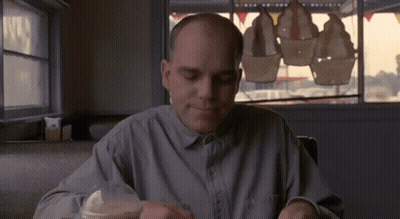Bald Man Sitting At Table In Diner GIF