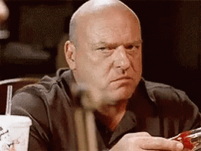 Bald Man Sitting At Table With Drink And Straw GIF