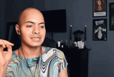 Bald Man Standing In Front Of Elvis Poster GIF