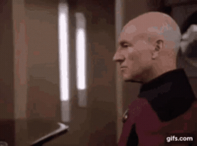 Bald Man Standing In Front Of Window GIF