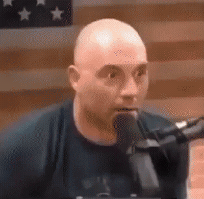 Bald Man Talking Into Microphone In Black Shirt GIF