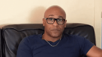 Bald Man Wearing Glasses Sitting GIF