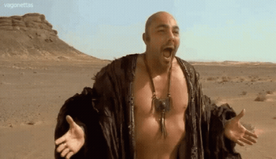 Bald Man With Arms Outstretched In Desert GIF