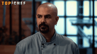 Bald Man With Beard And Earrings In Front Of Top Chef Sign GIF