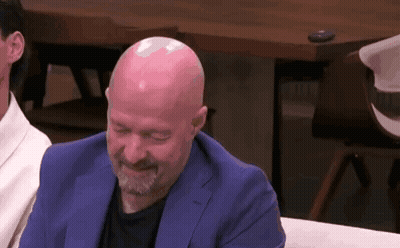 Bald Man With Beard In Blue Suit Laughing On Couch GIF