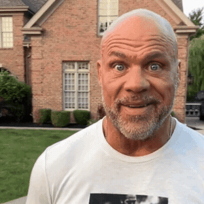 Bald Man With Beard In Front Of Brick House GIF