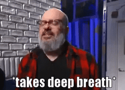 Bald Man With Beard In Glasses And Plaid Shirt Taking Deep Breath GIF
