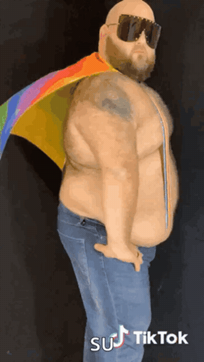 Bald Man With Beard in Sunglasses and Rainbow Cape
