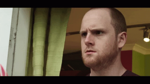 Bald Man With Beard Looking Out Window GIF