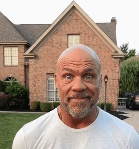 Bald Man With Beard Making Funny Face In Front Of Brick House GIF