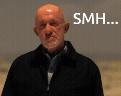 Bald Man With Beard Standing In Front Of SMH Sign GIF