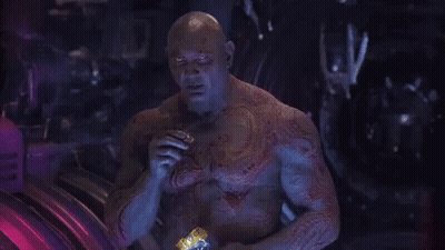 Bald Man With Chest Tattoo Sitting In Dark Room GIF