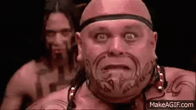 Bald Man With Face Tattoo In Front Of Another Bald Man GIF