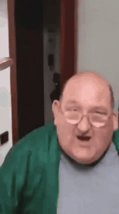 Bald Man With Glasses And Green Sweater Making Funny Face GIF