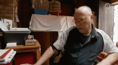 Bald Man With Glasses At Desk With Keyboard GIF