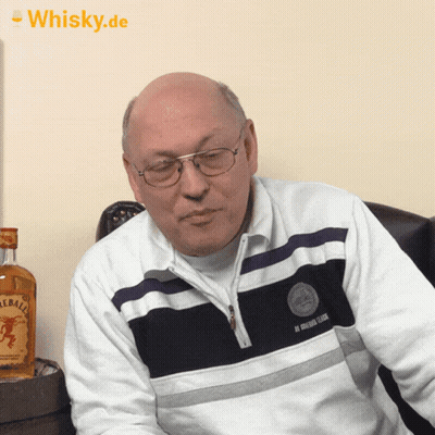 Bald Man With Glasses Sitting In Front Of Fireball Whiskey GIF