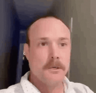Bald Man With Mustache And Earbuds GIF