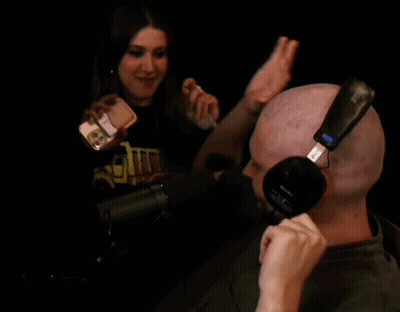 Bald Man With Sony Headphones Talking Into Microphone