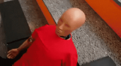 Bald Mannequin In Red Shirt On Concrete Floor GIF