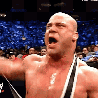 Bald Wrestler Shouting With Raised Arm To Crowd GIF