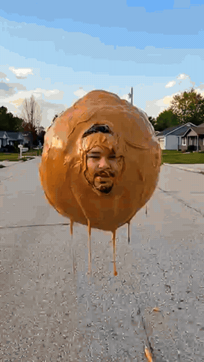 Balloon With Man's Face Floating Above Street GIF
