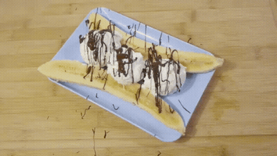 Banana Split With Whipped Cream And Chocolate Drizzle On Blue Plate GIF