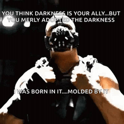 Bane From The Dark Knight Rises Is Wearing A Mask And Holding A Gun In His Hand . GIF