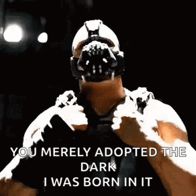 Bane From The Dark Knight Rises Is Wearing A Mask And Holding His Fist Up . GIF