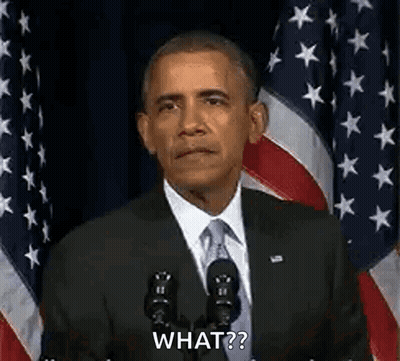 Barack Obama Is Giving A Speech In Front Of An American Flag While Standing In Front Of A Microphone . GIF