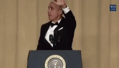 Barack Obama Is Standing At A Podium Holding A Microphone In His Hand . GIF