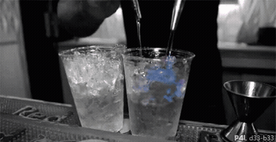 Bartender Pouring Drink Into Two Plastic Cups GIF
