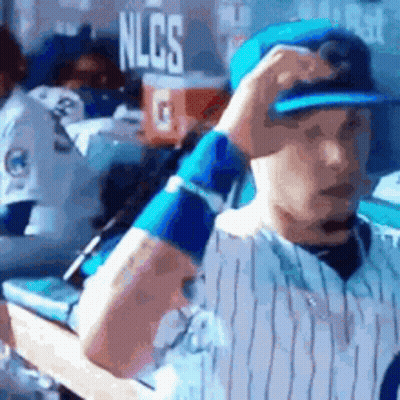 Baseball Player Adjusting Hat In Dugout GIF