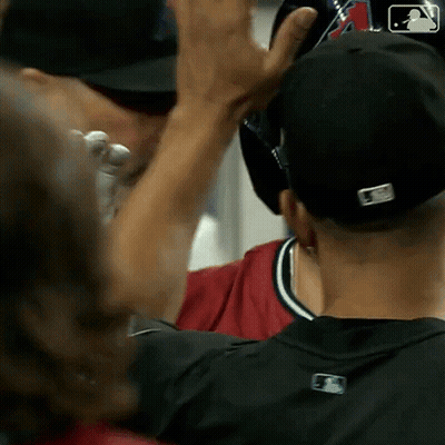 Baseball Player In Black Hat And Red Shirt High Fiving Another GIF