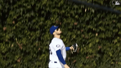 Baseball Player In Blue And White Uniform At Brick Wall GIF
