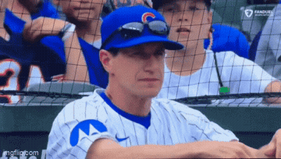 Baseball Player In Blue Hat With Letter C Sitting In Dugout GIF