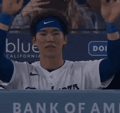 Baseball Player In Dugout With Bank Of Fame Sign GIF